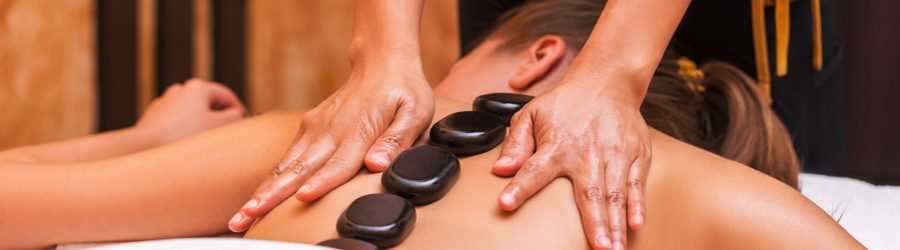 Woman getting thai herbal ball massage treatments in spa.